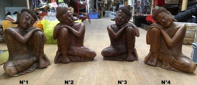Petite statue de Bouddha assis en bois la tête sur le genoux au repos