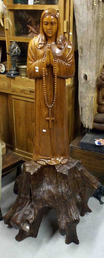grande statue de la vierge marie en bois sur une racine