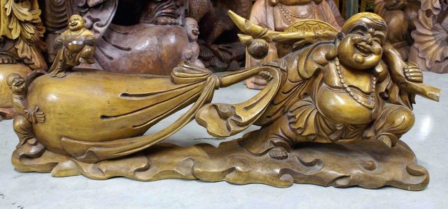 statue sculptée d'un Bouddha rieur avec son sac d'argent porte bonheur