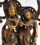 Grande statue de Krishna jouant de la flûte sous un arbre avec le couple de paons