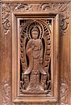 Cadre en bois sculpté d'un Bouddha debout