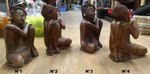 Petites statues de Bouddha assis en bois la tête sur le genoux au repos