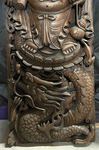 Grand cadre en bois sculpté d'un Bouddha rieur monté sur un dragon