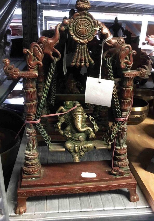 statue de ganesh en bronze assise sur une balançoire