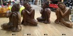 Petites statues de Bouddha assis la tête sur le genoux en bois