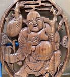 Cadre ovale en bois sculpt&eacute; d'un Bouddha rieur