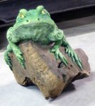 grande statue de grenouille sur un tronc en bois