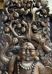 Grand cadre en bois sculpté d'un Bouddha rieur monté sur un dragon