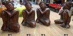 Petite statue de Bouddha assis la tête sur le genoux en bois