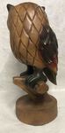 Grande statue de chouette en bois sur une branche