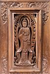 Cadre en bois sculpté d'un Bouddha debout